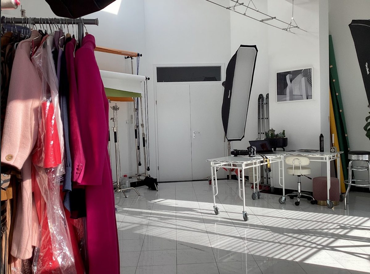 Fotostudio mit Kleiderstange voller Maentel und Lichtaufbau fuer ein Modeshooting — Das Studiozwei, Werbefotograf München
