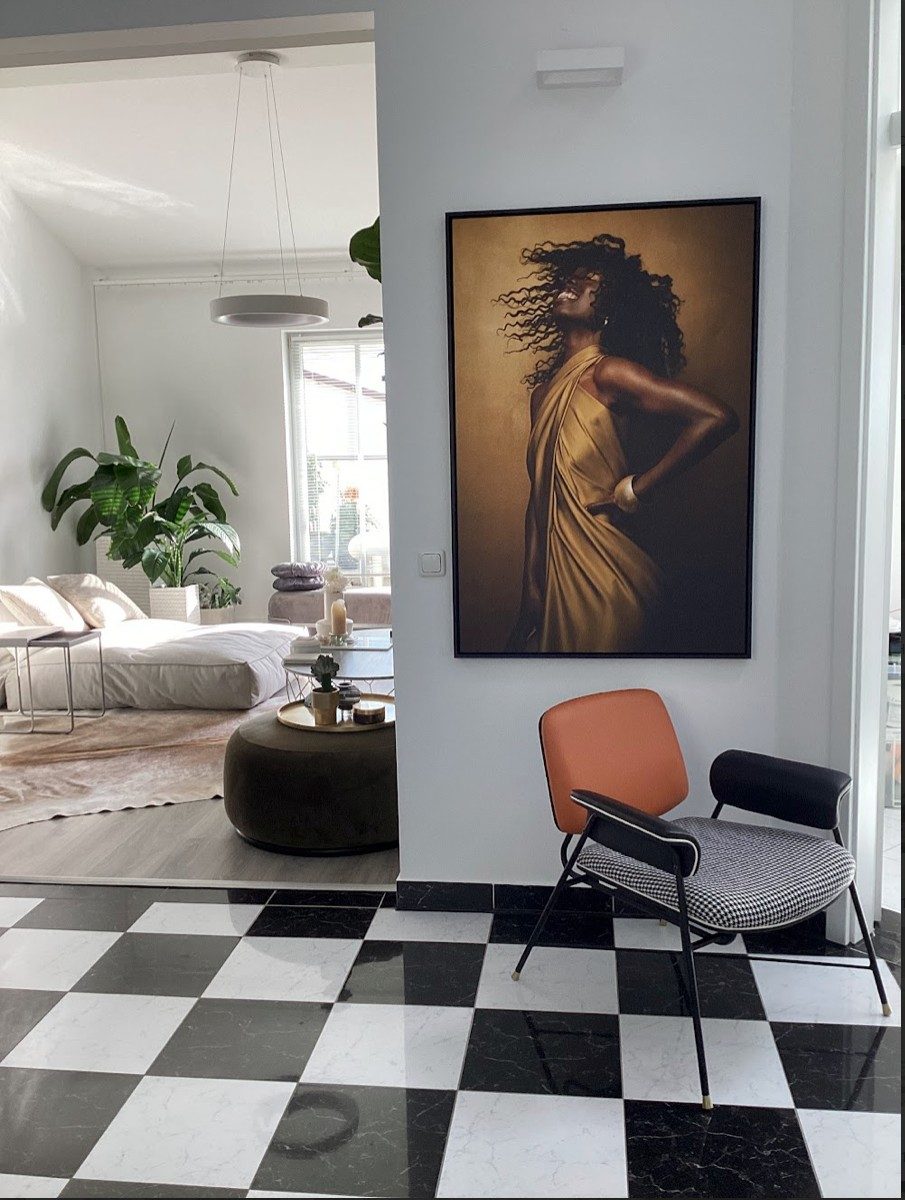 Wohnraum mit Schachbrettmarmorboden, grossem gerahmtem Portraet und Designsessel — Das Studiozwei, Werbefotograf München