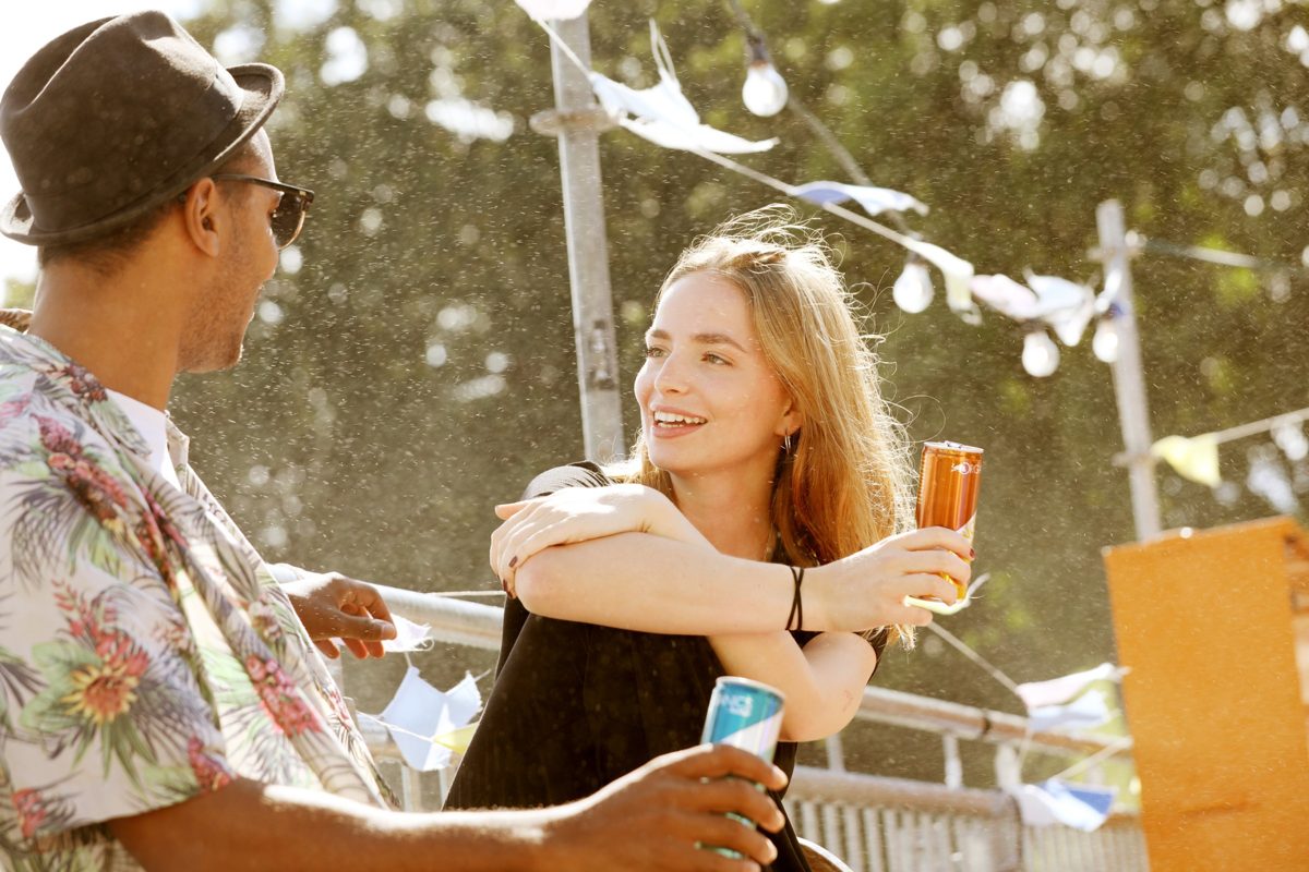 Zwei Menschen mit Getraenkedosen im Gegenlicht auf einem Sommerfest — Das Studiozwei, Werbefotograf München