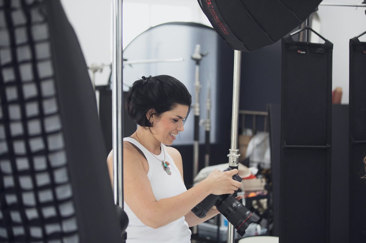 Fotografin mit Kamera am Set zwischen Lichtformern und Stativen — Das Studiozwei, Werbefotograf München