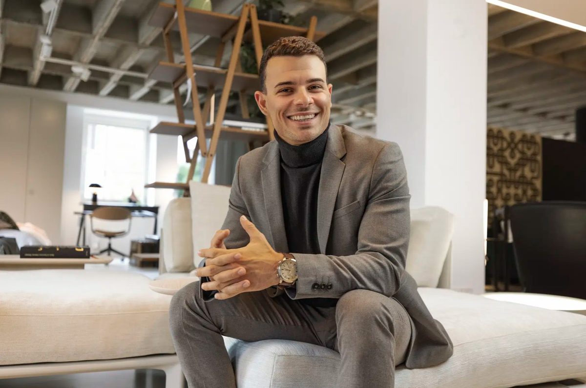 Businessportrait eines lachenden Mannes im grauen Anzug auf einem Sofa in einem hellen Loft — Das Studiozwei, Werbefotograf München