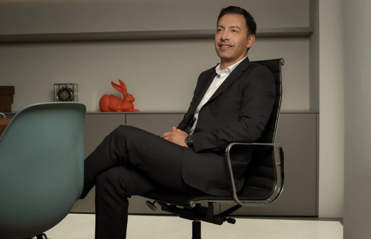 Businessportrait eines sitzenden Mannes im dunklen Anzug auf einem Drehstuhl in einem modernen Buero — Das Studiozwei, Werbefotograf München
