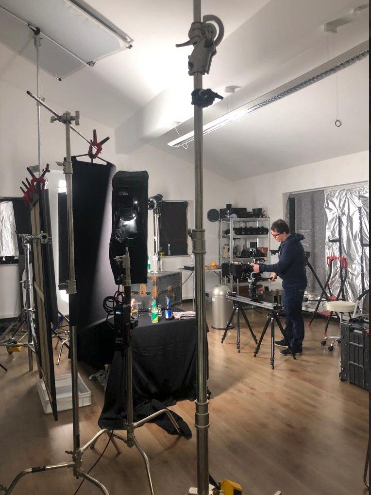 Fotograf bereitet im Studio ein Produktset zwischen Stativen und Softboxen vor — Das Studiozwei, Werbefotograf München